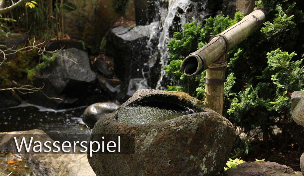 Ein kleiner chinesischer Wasserbrunnen mit einem Bambusrohr und Steinbecken.