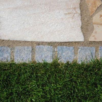Ein sauberer Randabschluss mit Pflastersteinen (Mosaik) zum Rasen.