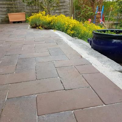 Eine alte gepflasterte Terrasse wurde repariert. Alle Steine sind wieder gerade und in gleicher Höhe verlegt.