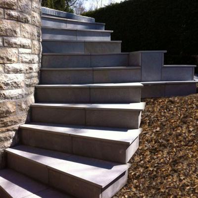 11-stufigeTreppe mit Feinsteinplatten und halbrund verlegt.